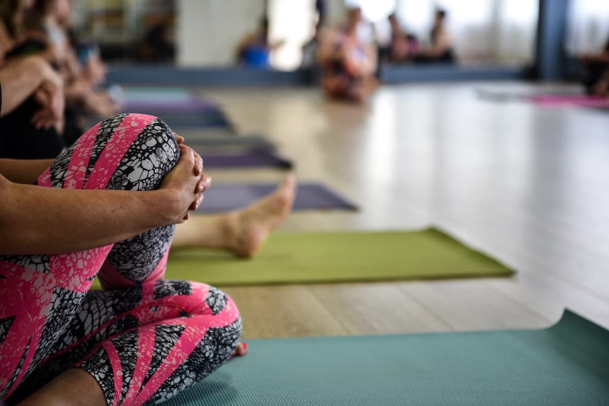 Students seated cross-legged on yoga mats at the Evolvere studio