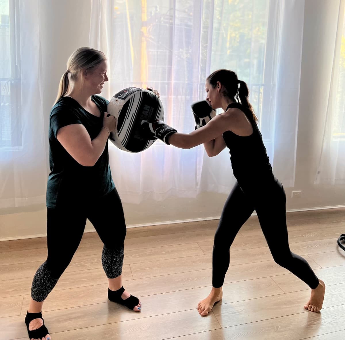 Boxfit class participants throwing punches during partner pad drills