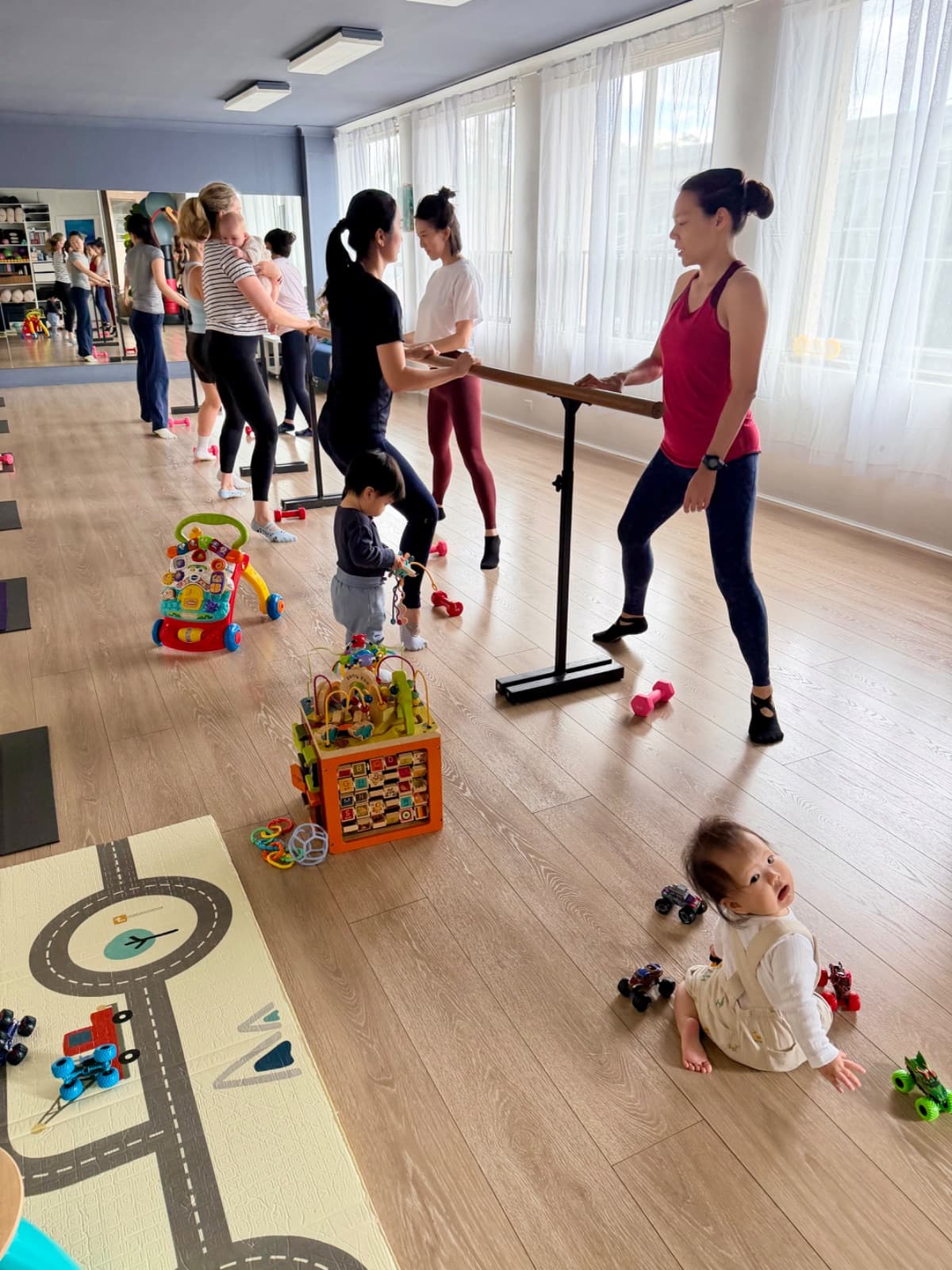 New mums holding the barre during a postnatal mums and bubs barre workout