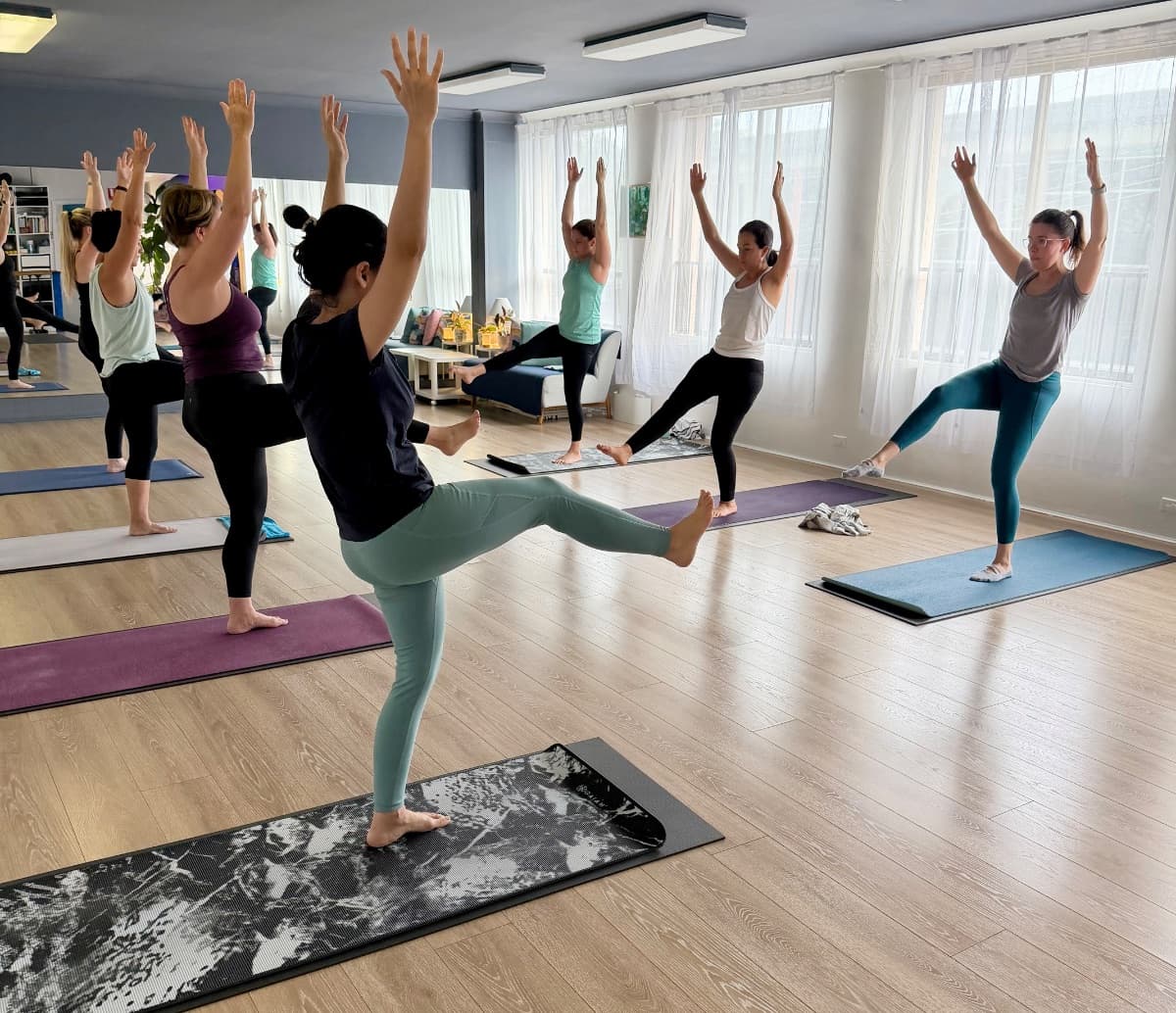 Yoga class in warrior pose at the sun-filled Evolvere studio