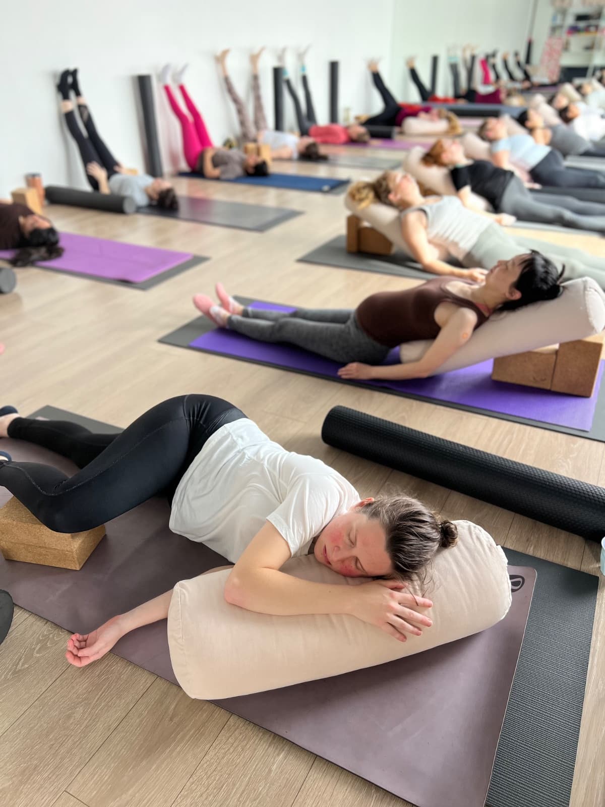 Pregnant woman resting on bolster during a prenatal yoga class in Lane Cove